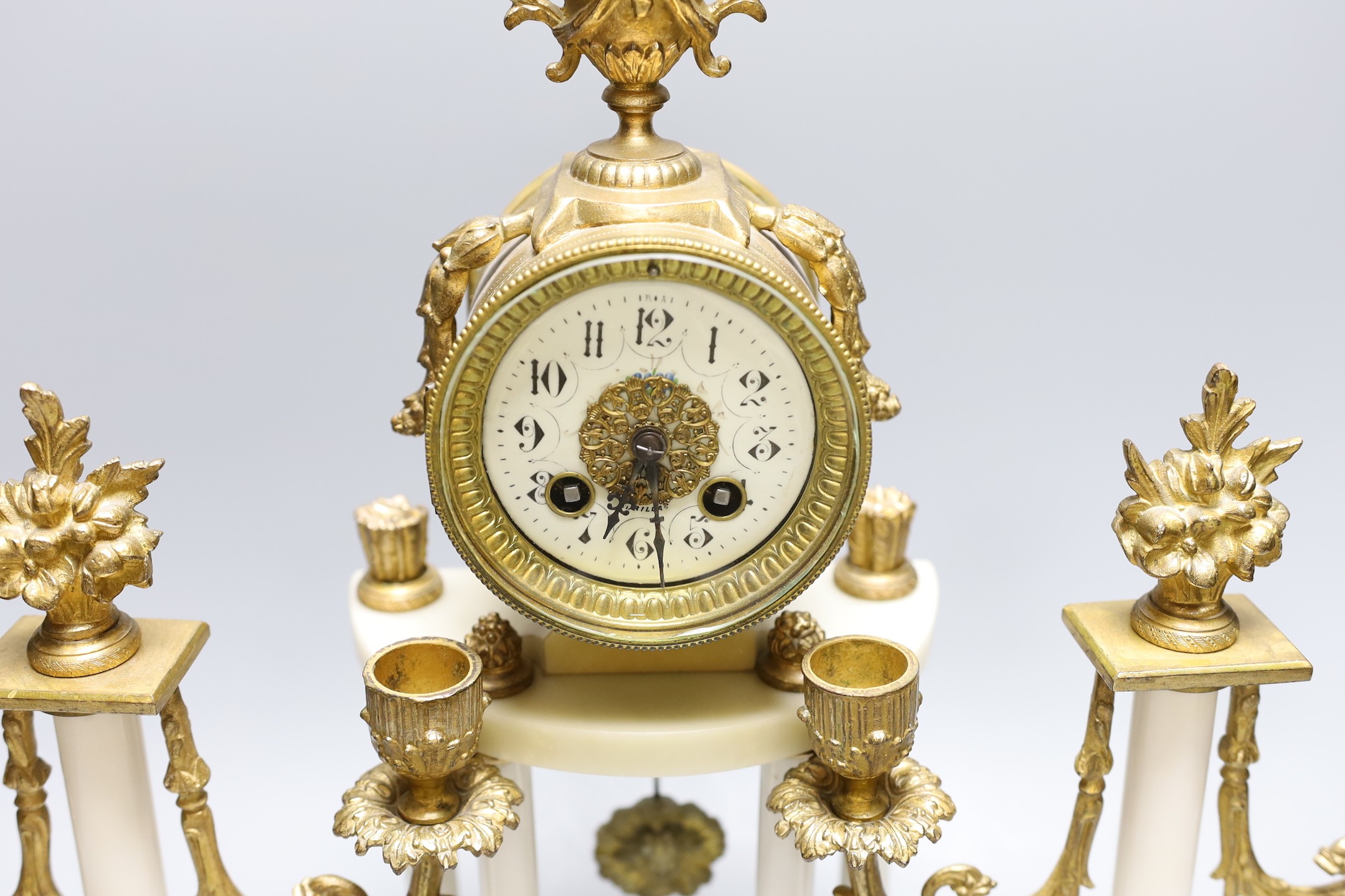 A four pillar French white marble and gilt metal clock garniture, 43 cms high